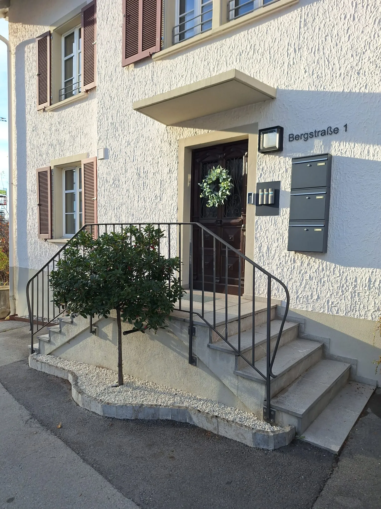 Neu gestalteter Eingangsbereich mit Zierkies und formgeschnittenem Bäumchen